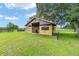 A barn with a partially enclosed stable, green grass and black fences at 7220 Nw 83 Ter, Ocala, FL 34482