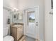 Bathroom area with a vanity, mirror, and white door leading to the outdoor area at 7220 Nw 83 Ter, Ocala, FL 34482