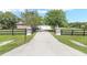 Long driveway leading to a charming home with a gated entrance and a beautifully landscaped yard at 7220 Nw 83 Ter, Ocala, FL 34482