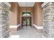 Elegant front entrance with stone columns and a grand double door entry at 7220 Nw 83 Ter, Ocala, FL 34482