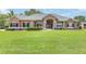 Manicured front yard featuring a sprawling lawn and a charming one-story home with elegant stone accents at 7220 Nw 83 Ter, Ocala, FL 34482