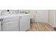 Laundry area featuring side-by-side washer and dryer, wash basin and door to exterior at 7220 Nw 83 Ter, Ocala, FL 34482
