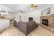 Open floorplan living room featuring stone fireplace, wood floors, and bar seating at 7220 Nw 83 Ter, Ocala, FL 34482