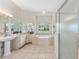 A spacious bathroom featuring a soaking tub, vanity, and glass-enclosed shower at 7220 Nw 83 Ter, Ocala, FL 34482
