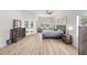 Bright main bedroom with wood floors, large windows, pool access, and rustic wood furniture at 7220 Nw 83 Ter, Ocala, FL 34482