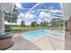 A screened in pool and hot tub with a view of the pasture and barn at 7220 Nw 83 Ter, Ocala, FL 34482