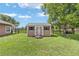 Charming shed featuring double doors, black shutters, and a well-maintained exterior, complementing the landscape at 7220 Nw 83 Ter, Ocala, FL 34482