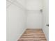 Empty walk-in closet with wood floor and wire shelving. Ready to be customized at 7220 Nw 83 Ter, Ocala, FL 34482