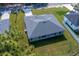 An aerial view of a house with modern roofing, complemented by a spacious green lawn and a charming covered patio at 7364 Sw 133 Ne Loop, Ocala, FL 34473