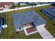 Aerial view of a well-maintained home with a neatly landscaped yard, patio, and a driveway leading to the garage at 7364 Sw 133 Ne Loop, Ocala, FL 34473