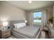 Comfortable bedroom with neutral tones, featuring a well-lit window and contemporary furnishings at 7364 Sw 133 Ne Loop, Ocala, FL 34473