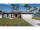 Charming single-story home with a manicured lawn, two-car garage, and inviting front entrance at 7364 Sw 133 Ne Loop, Ocala, FL 34473
