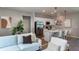 Cozy living room with kitchen view featuring a modern sofa, stainless steel appliances, and pendant lighting at 7364 Sw 133 Ne Loop, Ocala, FL 34473