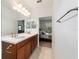 Bathroom with double sink vanity, tile floors, and view into bedroom at 7707 Sw 94Th Cir, Ocala, FL 34481