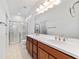 Bathroom featuring double sinks, a large mirror, and glass-enclosed shower at 7707 Sw 94Th Cir, Ocala, FL 34481