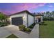 Charming single-story home featuring a well-manicured lawn, gray garage door, and inviting front entrance at 7707 Sw 94Th Cir, Ocala, FL 34481
