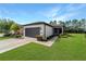 Charming single-story home featuring a well-manicured lawn, gray garage door, and inviting front entrance at 7707 Sw 94Th Cir, Ocala, FL 34481