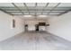 Spacious garage featuring sealed concrete floors, overhead lighting, and a refrigerator at 7707 Sw 94Th Cir, Ocala, FL 34481