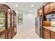 Kitchen with stainless steel refrigerator, tile floors, and view of an ornate china cabinet at 7707 Sw 94Th Cir, Ocala, FL 34481