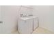 Clean laundry room with tile floor and modern side-by-side washer and dryer at 7707 Sw 94Th Cir, Ocala, FL 34481