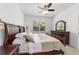 Comfortable main bedroom with a large window, dark wood furnishings, and plush bedding at 7707 Sw 94Th Cir, Ocala, FL 34481