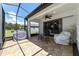 This screened patio features brick pavers, an outdoor dining area, and overlooks the backyard at 7707 Sw 94Th Cir, Ocala, FL 34481
