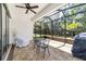 An inviting screened patio has a ceiling fan, brick pavers and views of the backyard at 7707 Sw 94Th Cir, Ocala, FL 34481