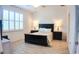 Bedroom showcasing a black bedframe and matching side tables with wood-look tile floor and lots of light at 7765 Sw 86Th Loop, Ocala, FL 34476