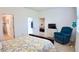 Comfortable bedroom with wood floors, a relaxing recliner, and access to a bathroom at 7765 Sw 86Th Loop, Ocala, FL 34476