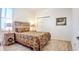 Cozy bedroom with a rustic headboard, colorful paisley bedding, and wood-look tile flooring at 7765 Sw 86Th Loop, Ocala, FL 34476