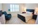 Bright bedroom features wood-look flooring, a dark wood bed frame, and a comfy recliner at 7765 Sw 86Th Loop, Ocala, FL 34476