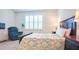 Bright bedroom features wood-look flooring, a dark wood bed frame, and a comfy recliner at 7765 Sw 86Th Loop, Ocala, FL 34476