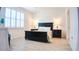 Bright bedroom features wood-look flooring, a dark wood bed frame, and ample natural light at 7765 Sw 86Th Loop, Ocala, FL 34476