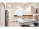 Well-lit kitchen with stainless steel appliances, granite countertops, tile backsplash, and seating at the breakfast bar at 7765 Sw 86Th Loop, Ocala, FL 34476