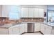 The kitchen offers white cabinets, stainless steel appliances, tile backsplash, and granite countertops at 7765 Sw 86Th Loop, Ocala, FL 34476