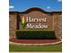 Entrance sign for Harvest Meadow community featuring decorative stone and manicured landscaping at 8187 Sw 60Th Ter, Ocala, FL 34476