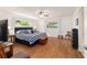 Well-lit bedroom with a large bed, wood floors, ceiling fan, and natural light at 8677 Sw 95Th Ln # A, Ocala, FL 34481