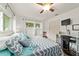 Comfortable bedroom featuring wood floors, a ceiling fan, and bright windows for natural light at 8677 Sw 95Th Ln # A, Ocala, FL 34481
