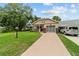 Inviting single-story home featuring a charming porch, screened garage, and lush green lawn at 8677 Sw 95Th Ln # A, Ocala, FL 34481