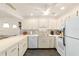 Open kitchen featuring white cabinets, tiled backsplash, and a ceiling fan at 8677 Sw 95Th Ln # A, Ocala, FL 34481