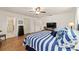 The spacious bedroom features a striped bedspread, wood floors, and an ensuite bathroom at 8677 Sw 95Th Ln # A, Ocala, FL 34481
