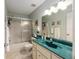 Bathroom with a green countertop, shower with glass door, and vanity with ample lighting at 9065 Sw 82Nd Ter # G, Ocala, FL 34481