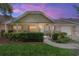 Charming single-story home with a covered front porch, stone accents, and well-maintained landscaping at dusk at 9065 Sw 82Nd Ter # G, Ocala, FL 34481