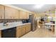 Bright kitchen featuring wood cabinets, laminate floors, modern appliances, and an open dining area at 9065 Sw 82Nd Ter # G, Ocala, FL 34481