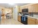 Modern kitchen featuring wood cabinets, laminate floors, and appliances, with an open-concept dining area at 9065 Sw 82Nd Ter # G, Ocala, FL 34481