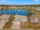 Stunning aerial view of a lakeside home with manicured lawn, lush landscaping, and a tranquil fountain at 9415 Se 125Th St, Summerfield, FL 34491