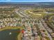 Aerial view featuring the home with lake view, lush green golf course, and mature trees at 9415 Se 125Th St, Summerfield, FL 34491