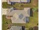 Aerial shot showcasing the home's roof, stone patio, landscaping, and pristine lawn at 9415 Se 125Th St, Summerfield, FL 34491