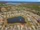 An aerial shot showcasing houses bordering a tranquil lake with mature trees and surrounding greenery at 9415 Se 125Th St, Summerfield, FL 34491