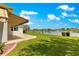 Expansive backyard with lush lawn and a serene lake view, enhanced by a stylish awning at 9415 Se 125Th St, Summerfield, FL 34491